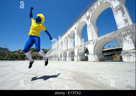 Blu eccitato il calcio brasiliano giocatore spettatore celebrando nei colori della squadra a Lapa archi in Rio de Janeiro Foto Stock