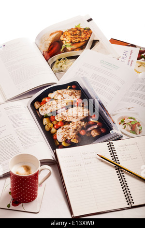I libri di cucina, notebook e caffè, la pianificazione delle settimane di dieta. Foto Stock