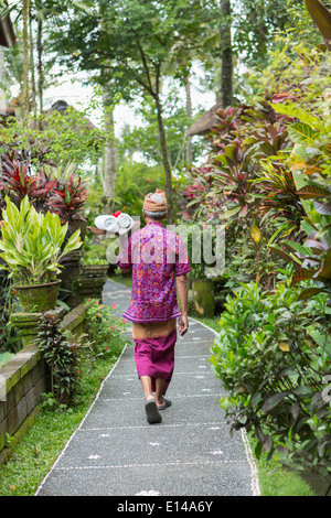 Lavoratore Balinese camminando lungo il percorso Foto Stock