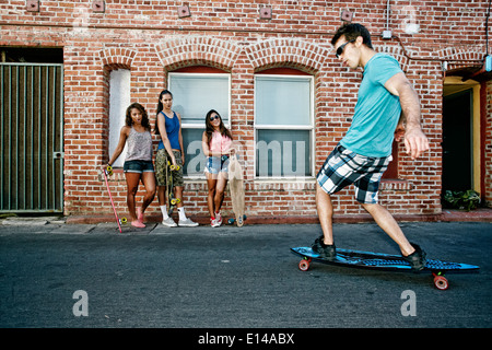 Amici longboards equitazione sulla strada di città Foto Stock