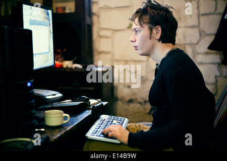 Uomo caucasico tramite il computer al banco Foto Stock