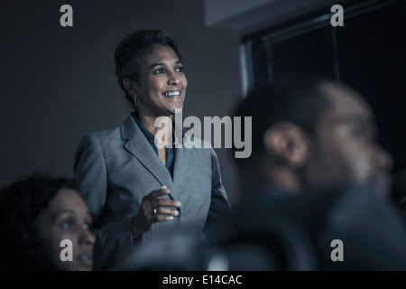 La gente di affari guarda la presentazione audio visiva in riunione Foto Stock