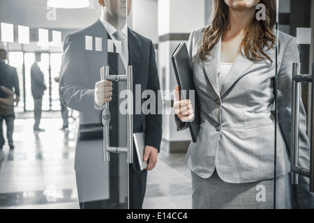 Imprenditore tenendo lo sportello aperto per collega femmina Foto Stock