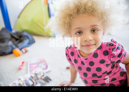 Razza mista ragazza sorridente sul pavimento Foto Stock