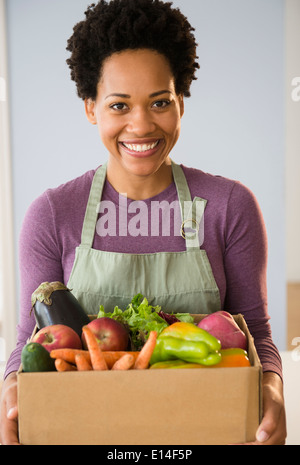 Ritratto di donna nera della scatola di contenimento di verdure Foto Stock