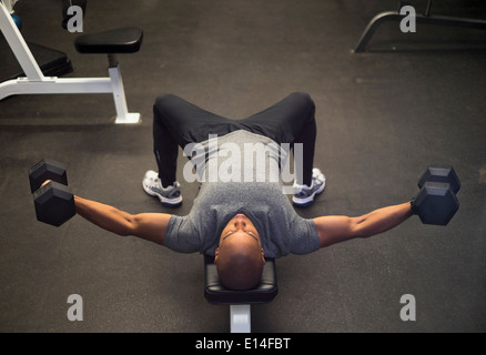 Uomo nero il sollevamento pesi nella palestra Foto Stock