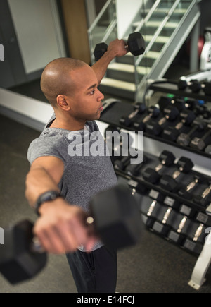 Uomo nero il sollevamento pesi nella palestra Foto Stock