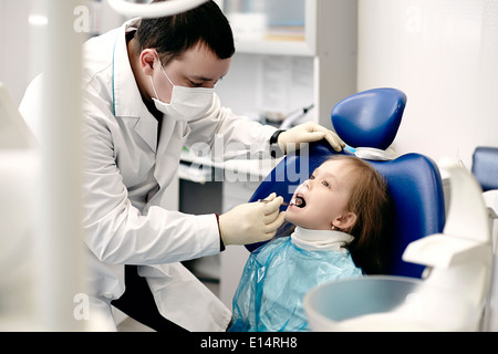 Dentista caucasica esaminando la ragazza denti Foto Stock