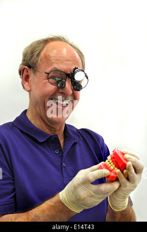 Dentista indossando un proiettore e tenendo un modello di dentizione Foto Stock