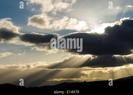 Raggi di sole rottura attraverso le nuvole nella luce della sera, vicino Barrydale, Route 62, Western Cape, Sud Africa Foto Stock