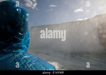 La donna a pioggia poncho guardando le Cascate del Niagara dalla cameriera nella nebbia, Ontario, Canada. Foto Stock