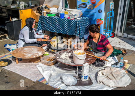 2 Asian ladies rendendo pane Naan nel mercato di strada. Foto Stock