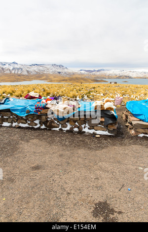 Mercato di Souvenir sulla strada di Ollantaytambo Perù Sud America. Manto colorato cappello panno sciarpa ponchos dalla lana di alpaca Foto Stock