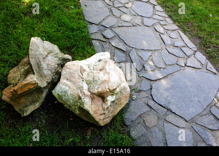 Percorso lastricato giardino e pietra in prato verde erboso Foto Stock