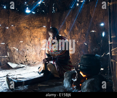 Un Samburu donna la cottura nel suo rifugio. Foto Stock