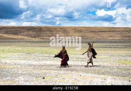 Turkana le donne a casa a piedi attraverso le infinite spazio intorno al lago Turkana. Foto Stock