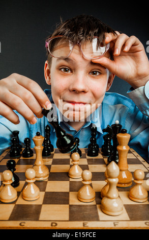 Wunderkind giocare a scacchi. Funny Nerd Ragazzo. Foto Stock