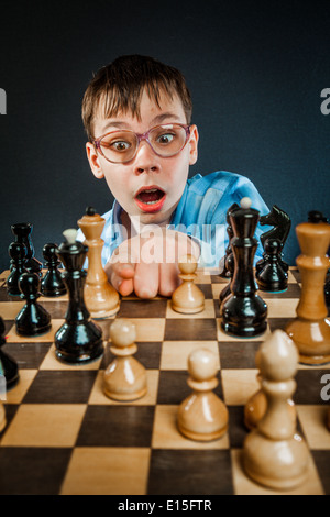 Wunderkind giocare a scacchi. Funny Nerd Ragazzo. Foto Stock