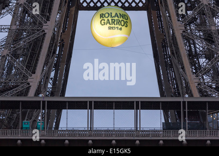 Torre Eiffel al tramonto con un gigante, illuminato palla da tennis appesa sopra la prima piattaforma per promuovere i 2014 francesi aperti. Foto Stock