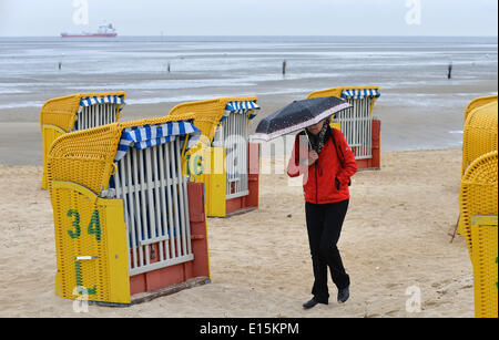 Cuxhaven-Doese, Germania. 23 Maggio, 2014. Un turista in vacanza Passeggiate con un ombrellone in spiaggia in Cuxhaven-Doese, Germania, 23 maggio 2014. Foto: CARMEN JASPERSEN/dpa/Alamy Live News Foto Stock