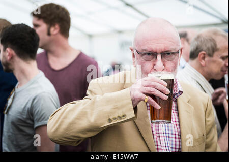 Stock, Essex. 23 Maggio, 2014. La prima pinta di birra viene degustato da una real ale fan per il giorno di apertura del cerchio del festival della birra, Essex più famosi pub festa della birra. Negli ultimi venti anni, il cerchio del festival della birra in Stock Village è diventato un evento annuale, disegno grave birra sorseggiando folk da lontano come in Norvegia e in Australia. Fotografo: Gordon Scammell/Alamy Live News Foto Stock