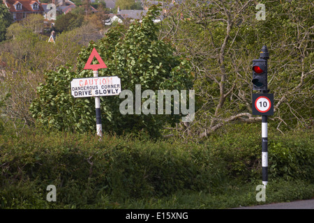 Attenzione angolo pericoloso guidare lentamente e 10 il limite massimo di velocità segnaletica stradale di fronte all'entrata al Castello di Carisbrooke, Carisbrooke, Newport, Isola di Wight Foto Stock