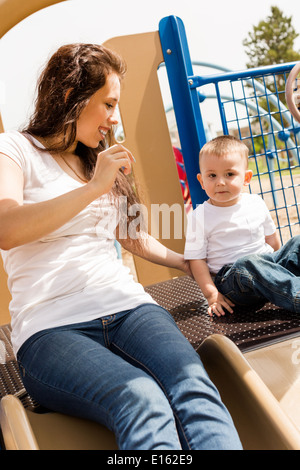 Giovane madre giocando con il suo bimbo figlio nel parco. Foto Stock