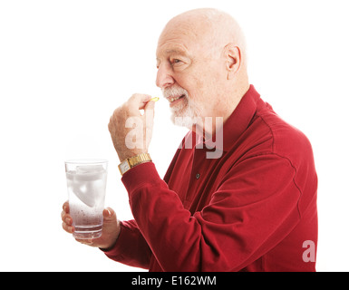 Bello il senior l uomo rimane sano prendendo un olio di pesce supplemento con un bicchiere d'acqua. Isolato su bianco. Foto Stock