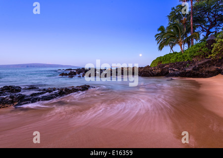 La Luna risplende su una spiaggia segreta di Maui. Foto Stock