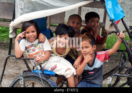 I bambini in pedicab, villaggio, Butuan, Filippine Foto Stock