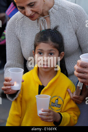 (140524) -- Vancouver (Canada), 23 maggio 2014 (Xinhua) -- Giovane partecipante accompagnato dal suo genitore presente alla veglia per commemorare il centenario della 'Komagata maru " tragedia nel Surrey, Canada, 23 maggio 2014. Centinaia di Indiani residenti partecipano in un lume di candela veglia il venerdì per commemorare il centenario della 'Komagata maru " tragedia di evocare l'attenzione sul problema del razzismo in Canada. Il 23 maggio 1914, il Komagata Maru, un Giapponese steamship, arrivati a Vancouver di Coal Harbour trasportare 376 passeggeri da India. Dopo aver trascorso due mesi all'ancoraggio, il governo ha rifiutato Foto Stock