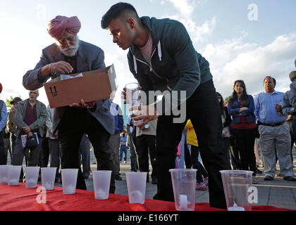 (140524) -- Vancouver (Canada), 23 maggio 2014 (Xinhua) -- i partecipanti aiutano a distribuire le candele alla veglia per commemorare il centenario della 'Komagata maru " tragedia nel Surrey, Canada, 23 maggio 2014. Centinaia di Indiani residenti partecipano in un lume di candela veglia il venerdì per commemorare il centenario della 'Komagata maru " tragedia di evocare l'attenzione sul problema del razzismo in Canada. Il 23 maggio 1914, il Komagata Maru, un Giapponese steamship, arrivati a Vancouver di Coal Harbour trasportare 376 passeggeri da India. Dopo aver trascorso due mesi all'ancoraggio, il governo ha rifiutato di allo Foto Stock