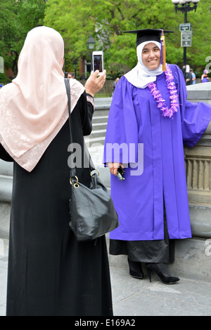 Un arabo musulmano studente in cap & vestaglia e sua madre per celebrare la graduazione da NYU nel Greenwich Village di New York City Foto Stock