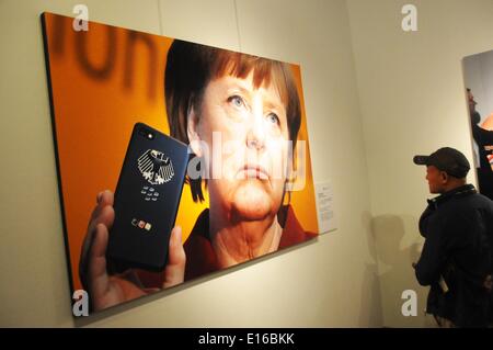 Pechino, Cina. Xxiv Maggio, 2014. Un visitatore visualizza la foto "Angela Merkel e il suo cellulare" al decimo China International Press Photo Contest (CHIPP) vincente mostra fotografica a Pechino Capitale della Cina, 24 maggio 2014. La mostra, visualizzazione 229 foto vincitrici, dato dei calci fuori alla Cina Monumento Millenario di sabato. © Wang Zhen/Xinhua/Alamy Live News Foto Stock