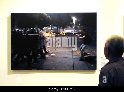 Pechino, Cina. Xxiv Maggio, 2014. Un visitatore visualizza la foto "affrontare con il Team di tiro' al decimo China International Press Photo Contest (CHIPP) vincente mostra fotografica a Pechino Capitale della Cina, 24 maggio 2014. La mostra, visualizzazione 229 foto vincitrici, dato dei calci fuori alla Cina Monumento Millenario di sabato. © Wang Zhen/Xinhua/Alamy Live News Foto Stock