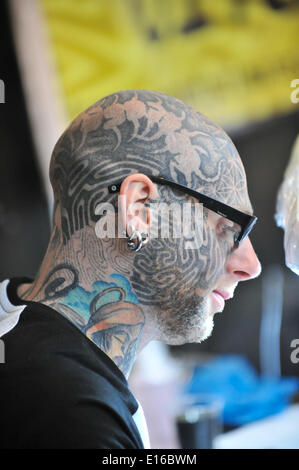 Alexandra Palace di Londra, Regno Unito. Il 24 maggio 2014. Un tattooist con il suo volto coperto di tatuaggi e si concentra sul suo lavoro presso il Great British Tattoo Show avrà luogo questo fine settimana a Alexandra Palace. Lo spettacolo presenta un tatuaggio, in stallo la vendita di abbigliamento e accessori, wrestling e una sfilata di moda Credito: Matteo Chattle/Alamy Live News Foto Stock