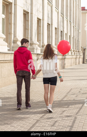 Moda giovane elegante giovane in amore in posa mattina su un vuoto che la strada della citta'. Tanga ragazza carina con bel uomo avente Foto Stock