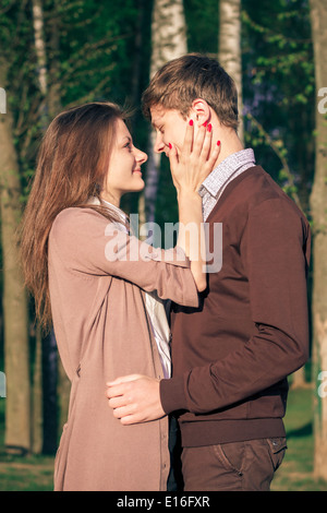 Moda giovane elegante giovane in amore in posa di una città europea park. Tanga ragazza carina con uomo bello divertirsi outd Foto Stock