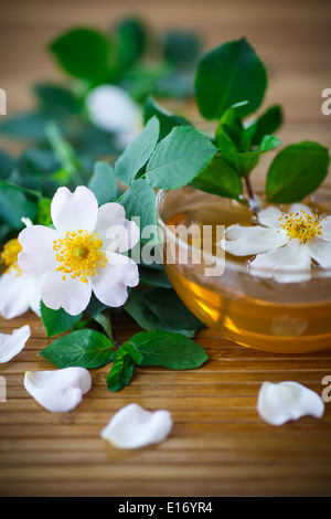 Il tè di petali di rosa in un bicchiere sul tavolo Foto Stock