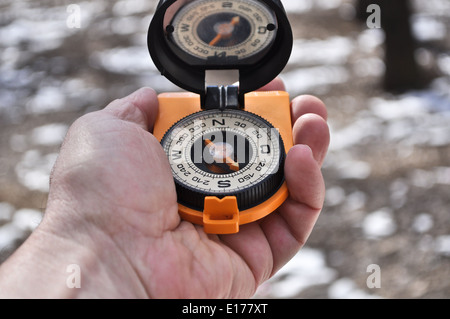 L'uomo tiene in mano la bussola magnetica, per non perdersi lontano da casa. Foto Stock