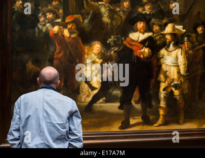 Visitatore al Rijksmuseum ad Amsterdam in Olanda, guardando Rembrandt La Ronda di Notte Foto Stock