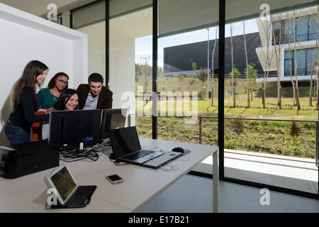 Gli impiegati a discutere di un progetto mentre guardando lo schermo di un computer Foto Stock