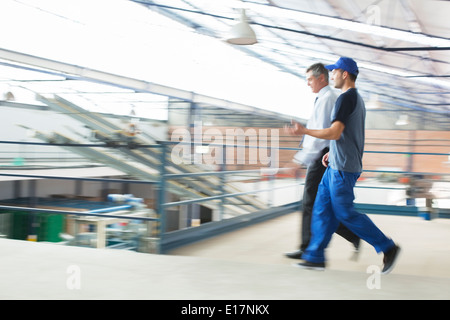 Supervisore e lavoratore a piedi nella stabilimento di trasformazione alimentare Foto Stock