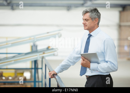 Supervisore con tavoletta digitale in stabilimento di trasformazione alimentare Foto Stock