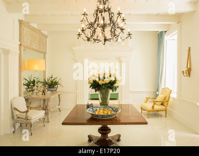 Lampadario su bouquet di rose sul tavolo nel foyer di lusso Foto Stock