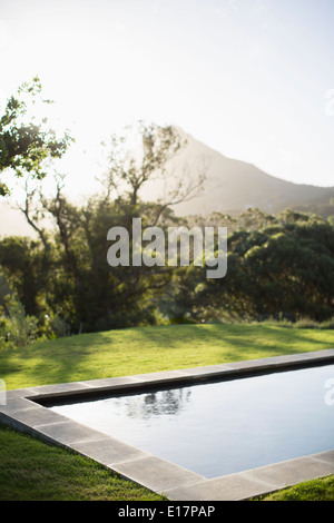 Sole che splende sulla montagna di lusso e lap pool Foto Stock