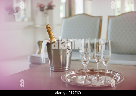 Champagne in argento secchio accanto a champagne flauti Foto Stock