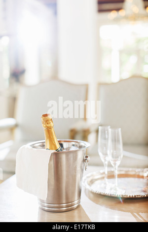 Champagne in argento secchio accanto a champagne flauti Foto Stock