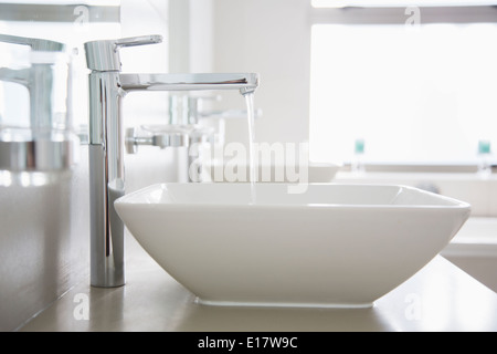 Versare acqua dal rubinetto nel bagno moderno Foto Stock