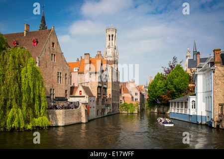 Turisti in giro in barca attraverso i canali di Bruges, Belgio Foto Stock